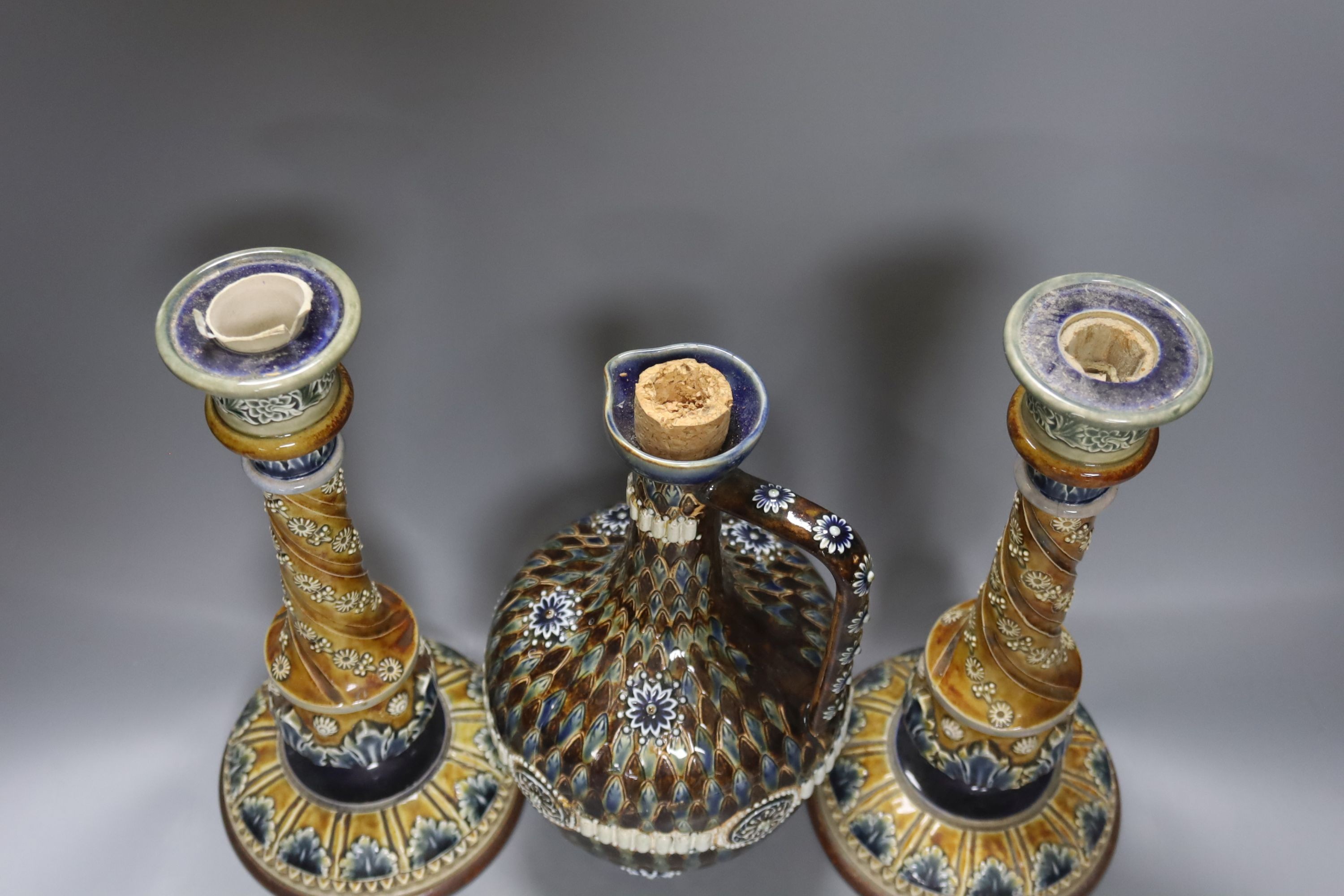 A pair of Doulton Lambeth stoneware candlesticks, height 30cm, and a similar 1878 ewer (cracked)
